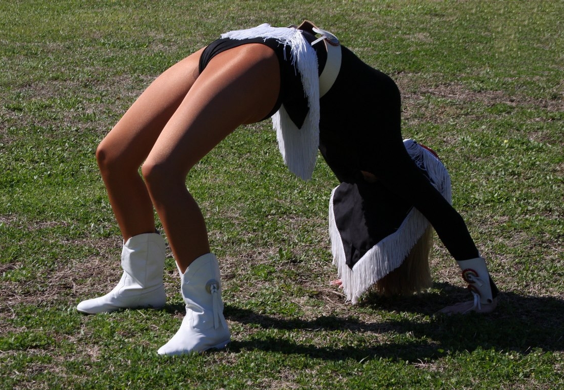 Cheerleader Slut showing Upskirt in Tan Opaque Lycra Pantyhose, White Boots and Black Panties